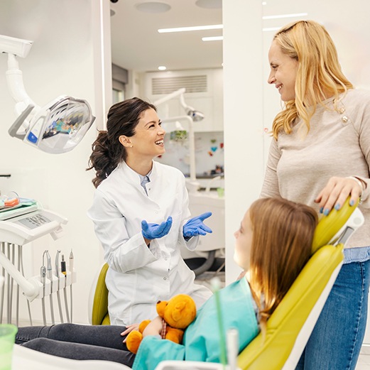 a pediatric dentist speaking with a parent and patient