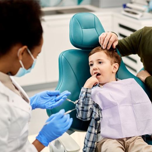 a boy pointing at his painful tooth for his dentist