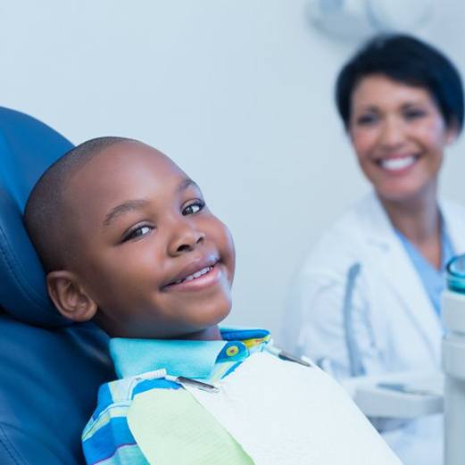 a child smiling while undergoing a dental visit