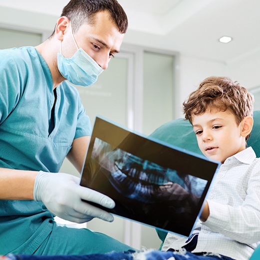 Dentist showing young boy X-rays of teeth