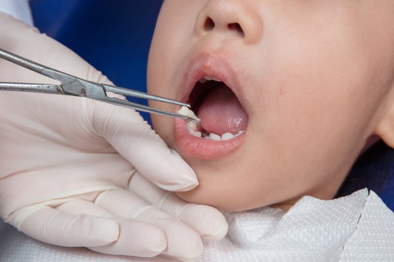 Little girl having a tooth extracted at dentist’s office